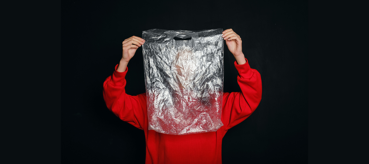 Image of a person holding a used and dirty plastic bag