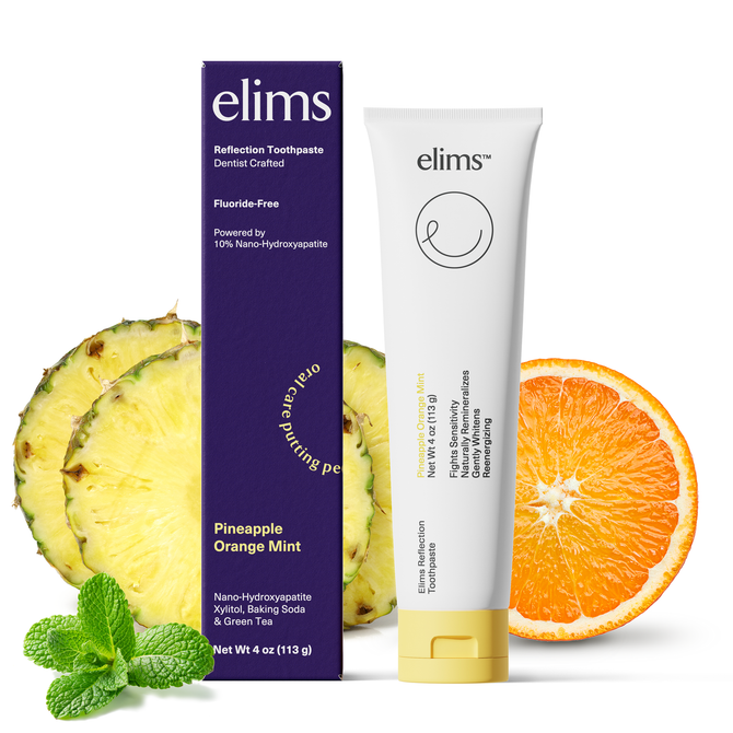 Elims toothpaste tube and packaging with pineapple, orange, and mint leaves on a white background