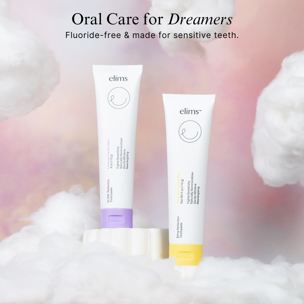 Two Elims nano-hydroxyapatite for sensitive teeth toothpaste tubes on a fluffy white surface with a soft pink background. one is lavender toothpaste and the other is fruit flavor toothpaste