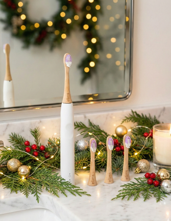 Set of electric toothbrushes on a decorative bathroom counter with Christmas decorations.