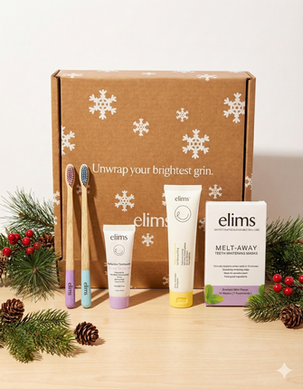 image of elims products laid out in a neat line on a wood table with pine cones and elims gift box behind it