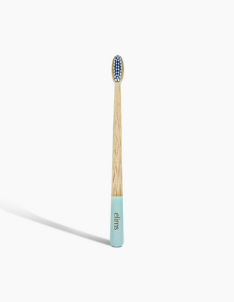 A sustainable bamboo toothbrush with a blue-dipped handle and soft bristles, branded with the 