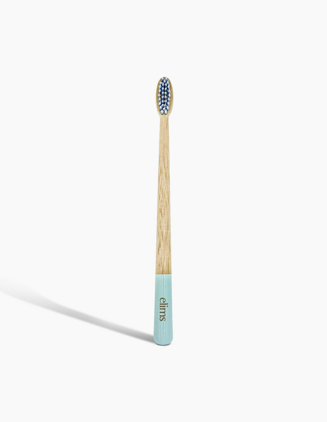 A sustainable bamboo toothbrush with a blue-dipped handle and soft bristles, branded with the 