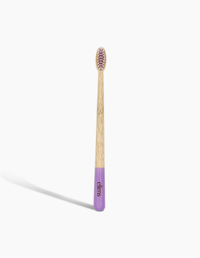 A sustainable bamboo toothbrush with a purple-dipped handle and soft bristles, branded with the 