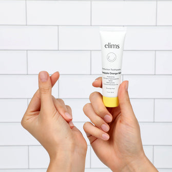 love for elims pineapple orange mint toothpaste on white background