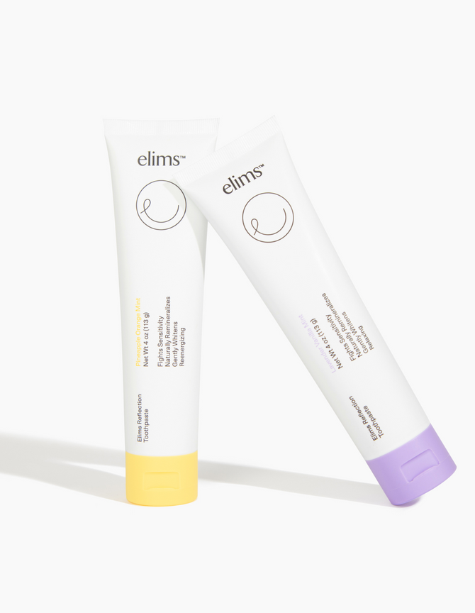 aTwo upright tubes of ELIMS Reflection fluoride-free toothpaste, Lavender Vanilla Mint (purple cap) and Pineapple Orange Mint (yellow cap), from the Variety 2-Pack